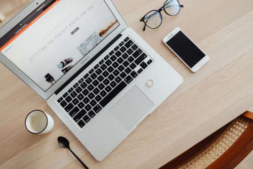 Laptop, phone mi photo lenses on desk