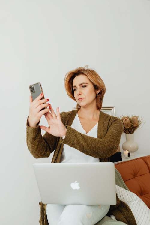 A woman works using a laptop from her couch at home