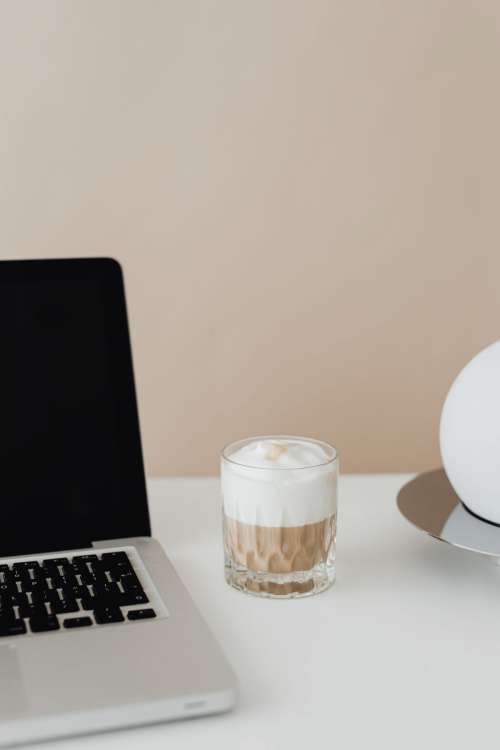 Laptop and a glass of Cafe Latte on the desk