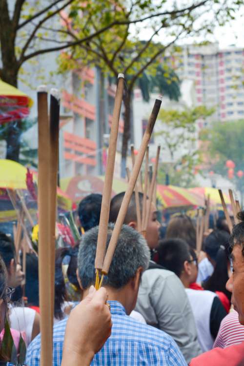 Street Full Of People Holding Long Sticks With Burnt Ends Photo