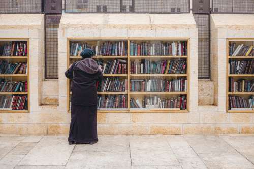 Person Browsing Books In An Outdoor Library Photo