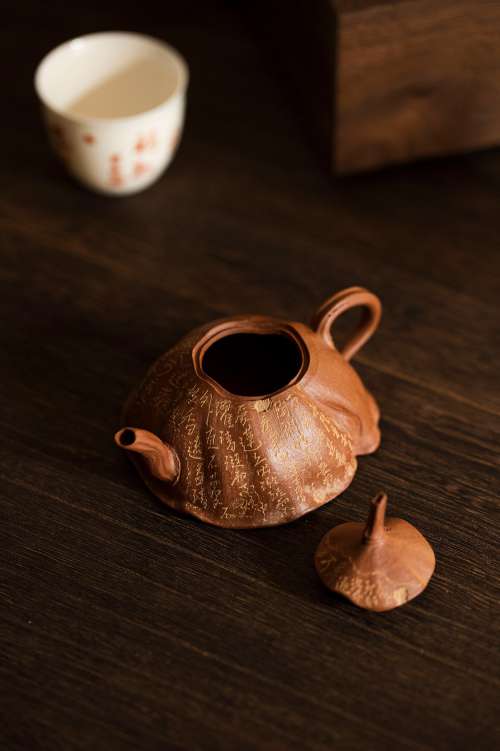 Rust Colored Teapot With Its Lid Of On A Wooden Table Photo