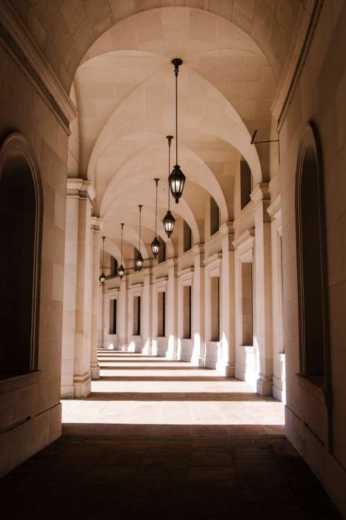 White Arched Hallway With Natural Light Photo
