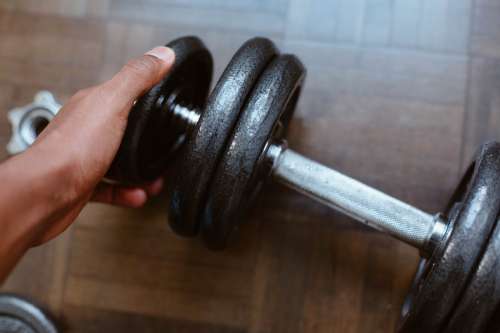 Close Up Of A Hand Adding Weight To A Dumbbell Photo