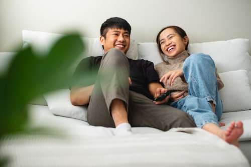 A Couple Laughing And Relaxing Together On Their Couch Photo