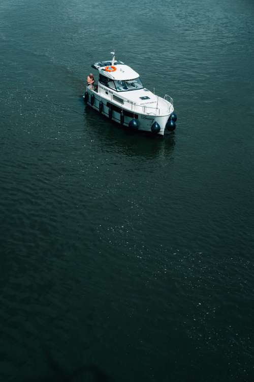 White Boat With Person In Dark Blue Water Photo