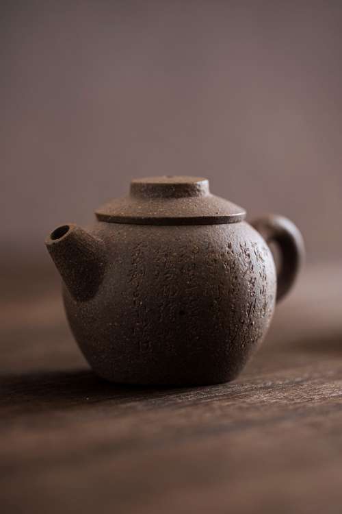 Close Up Of A Mini Round Teapot With Letters Carved Photo