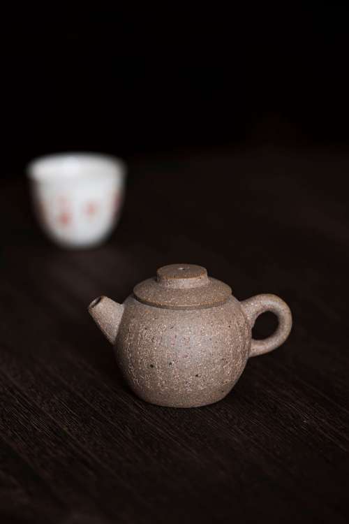 A Round Mini Teapot On A Dark Wooden Surface Photo