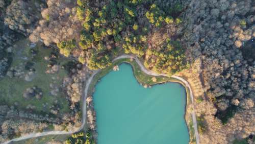Aerial Photo Of A Body Of Water Surrounded By Trees Photo