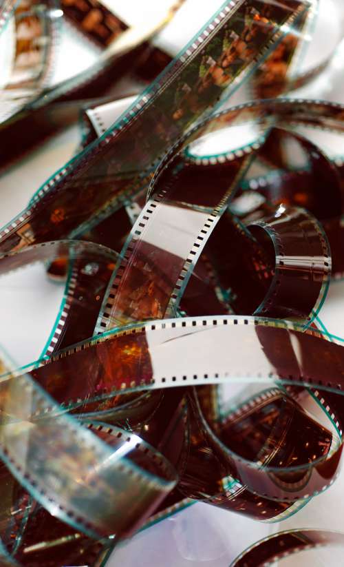 A Film Reel Lays Tangled Against A White Background Photo