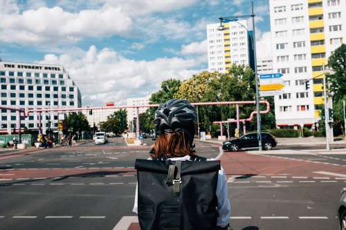 Person With Black Helmet Waits Their Turn In City Intersection Photo