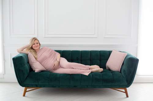 Person Lays On A Dark Green Couch And Smiles Photo