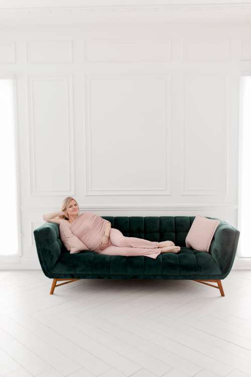 Person In Pink Lays On A Green Couch Photo