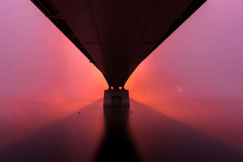 Sunrises Under A Stone Bridge Creating A Pink Sky Photo
