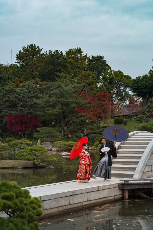 Two People Smile Holding Umbrellas On A Walkway Photo