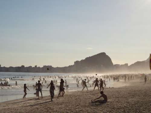 Misty Crowded Beach With Hills And Buildings Photo