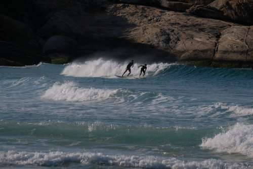 Two People Surfing In Blue Choppy Water Photo