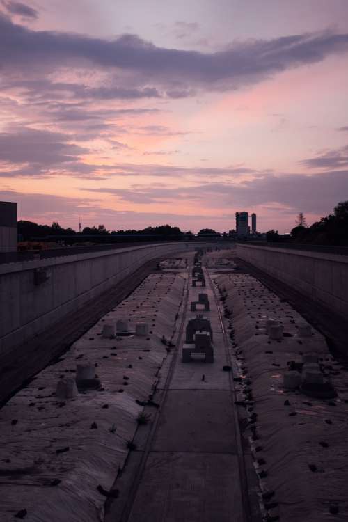 Sunsets On A Large Cement Pathway Lined With Flowers Photo