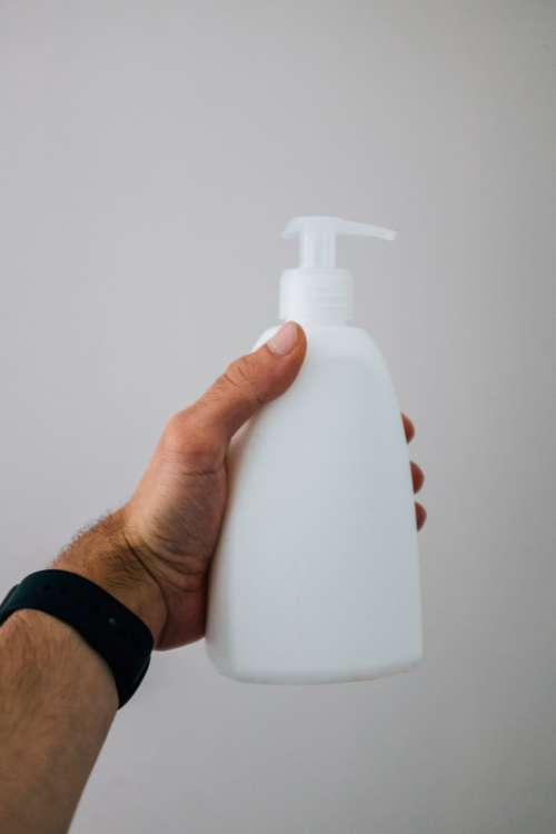 Hand Holding A White Pump Bottle Photo