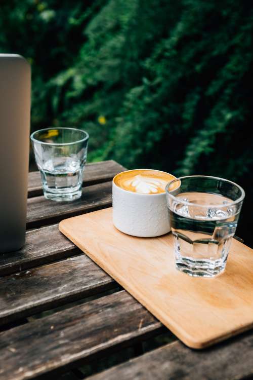 Picnic Table With A Wooden Tray Holding A Latte And A Water Photo