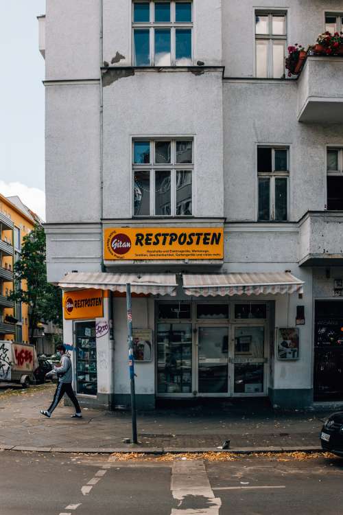 Tall Building With An Orange Sign That Says Restposten Photo