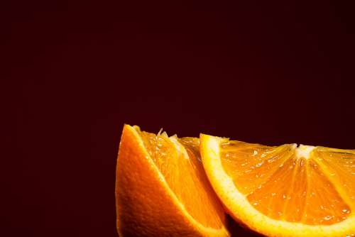Two Juicy Orange Slices Against Red Background Photo