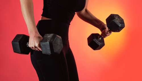 Person Dressed In Black Holds Two Weights In Each Hand Photo