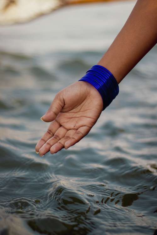 A Hand Cupped Over Wavy Water Photo