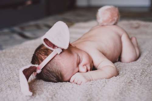 Newborn baby with bunny ears and a tail