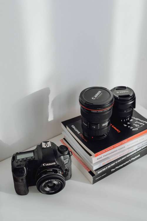 Photographer's desk - books, DSLR camera and lenses