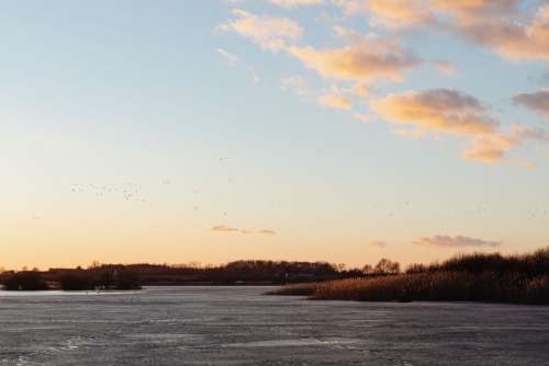 Melting ice on the lake in winter at sunset