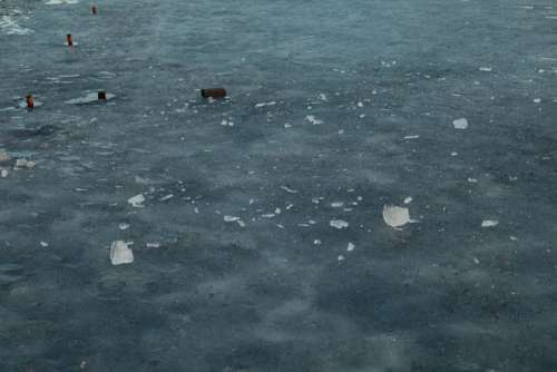 Melting ice on the lake in winter at sunset