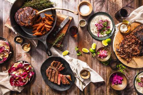 Flatlay Iron Skillet With Meat And Other Food Photo
