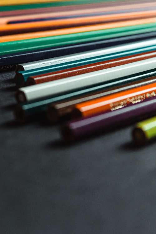 Colored Pencils Lines Up On A Black Background Photo