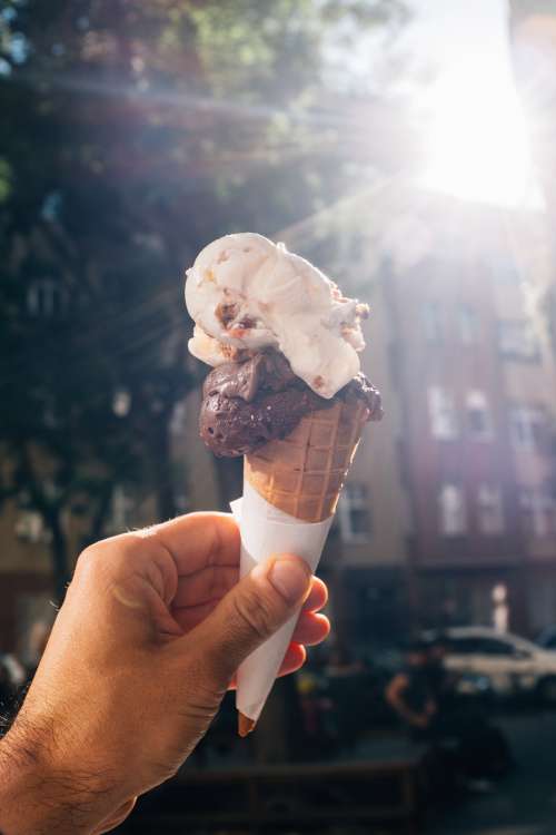 Hand Holds Up A Two Scoop Ice Cream Cone Photo