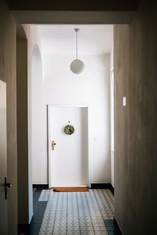 A White Door At The End Of A Long White Hallway Photo