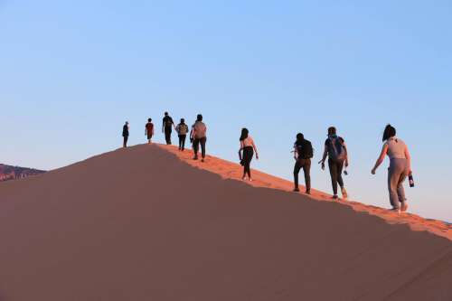 Tourists Hike Up Steep Sand Dune Photo