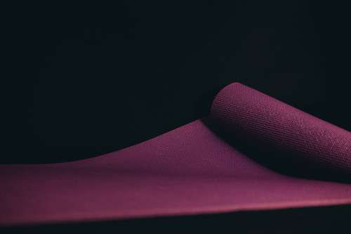 Purple Yoga Mat Unrolled On A Black Floor Photo