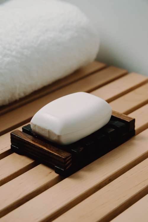 One Bar Of White Soap Lays In A Wooden Holder Photo