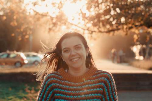 Woman Smiles At Golden Hour Into A Camera Photo