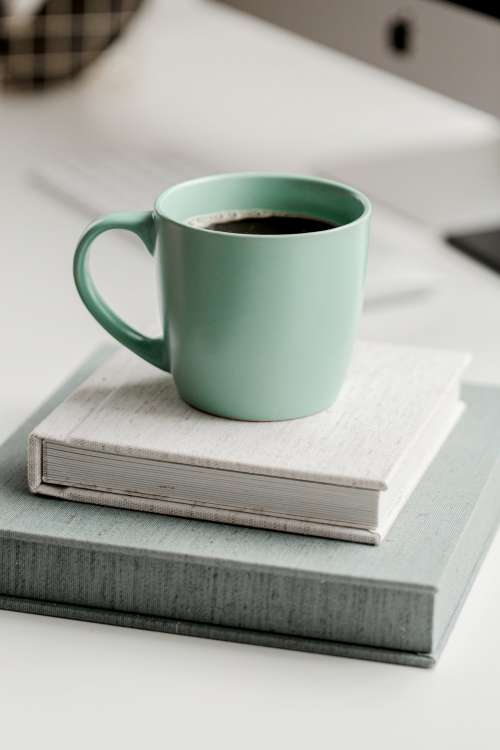 Mint Green Mug Full Of Black Coffee On Top Of Books Photo