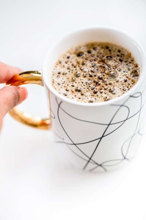 Fingers Pinch The Handle Of Mug Of Hot Chocolate Photo