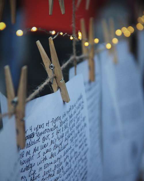 Clothes Pins Holds Up White Paper With Writing Photo
