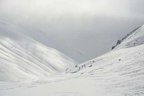 Three People Hiking Up A Snow Covered Mountain Photo