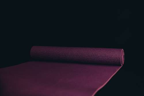 Unrolled Yoga Mat Against A Black Background Photo