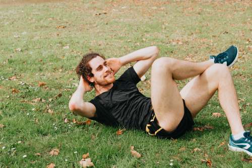 Person Lays On Grass And Crunches In A Situp Photo