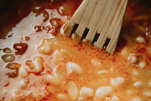 Close Up of A Red Sauce And A Wooden Spoon Photo