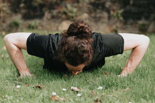 Person Does A Push Ups Outdoors In The Grass Photo