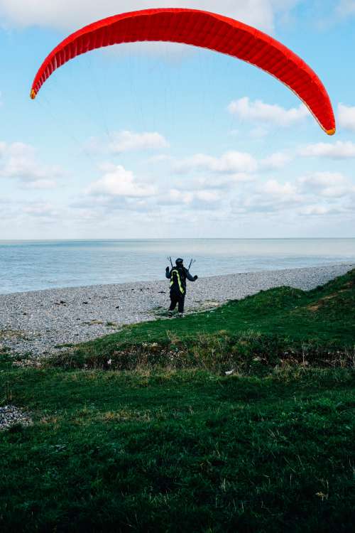 Person On The Shore With A Red Kite For Surfing Photo