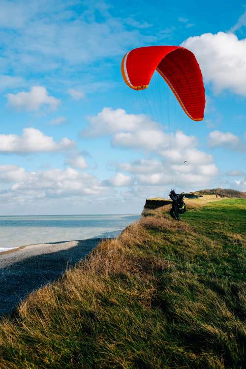 Person Stands On A Grassy Hill Kite Surfing Photo